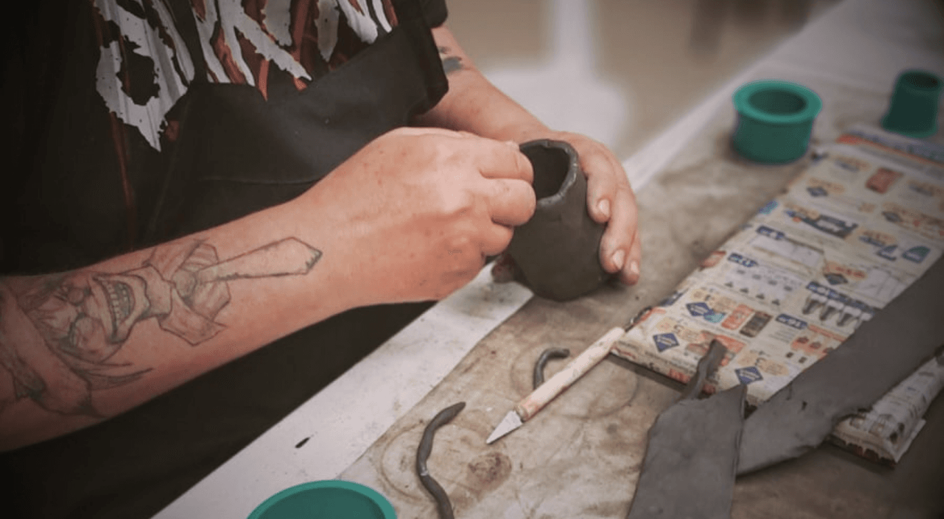 Mãos trabalhando a argila — aulas no ateliê